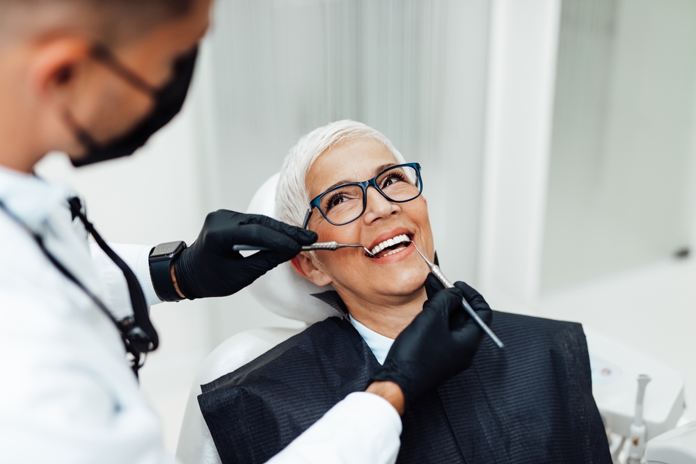 A beautiful senior woman receiving dental treatment at Spencer Dental in Maryville, with a caring dentist